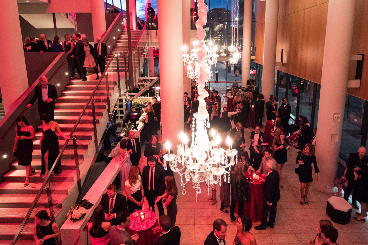 Event in Orchestra Hall foyer with red lighting and chandeliers 