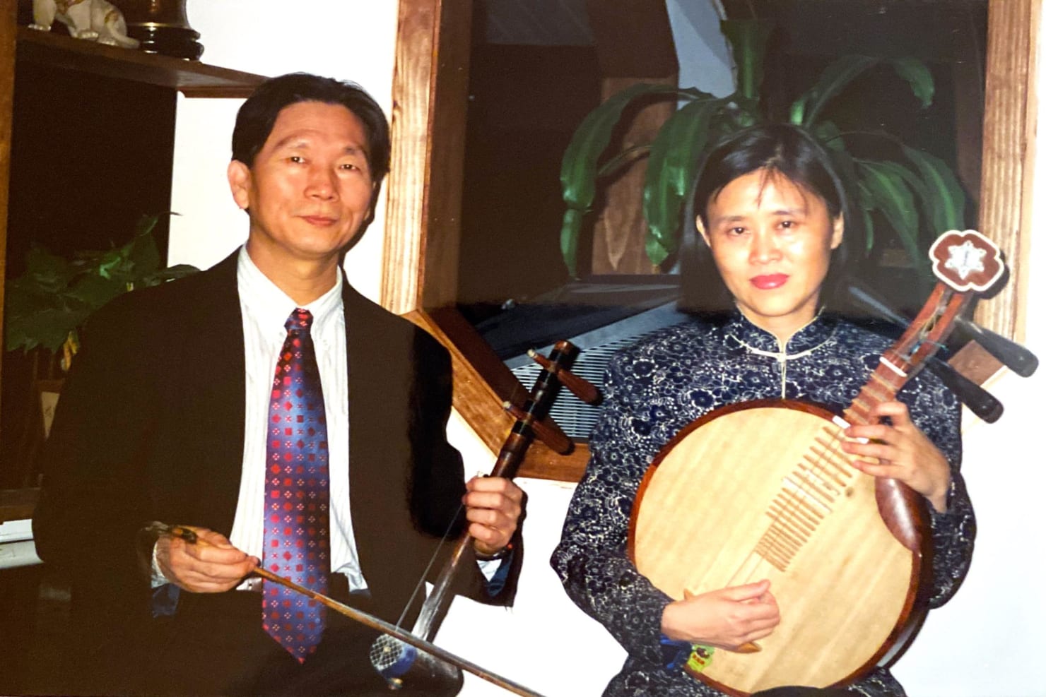 Zhengang, left, and Mei Hu, right, pose with the jing hu and yue qin respectively