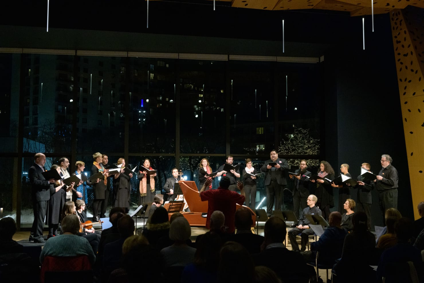 Border CrosSing choral ensemble sings on stage while audience watches