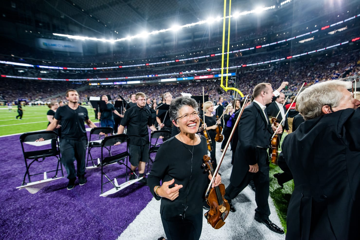 Deborah Serafini and the Minnesota Orchestra exiting the field at U.S. Bank Stadium