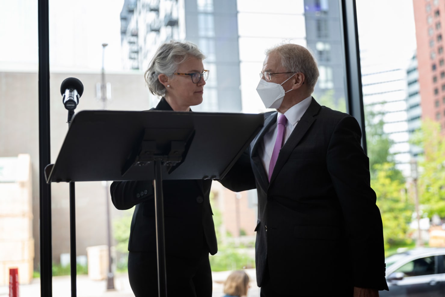 Two figures--Kathryn Nettlemen on left, Osmo Vanska on right--on a stage behind a microphone and music stand, embracing one another.