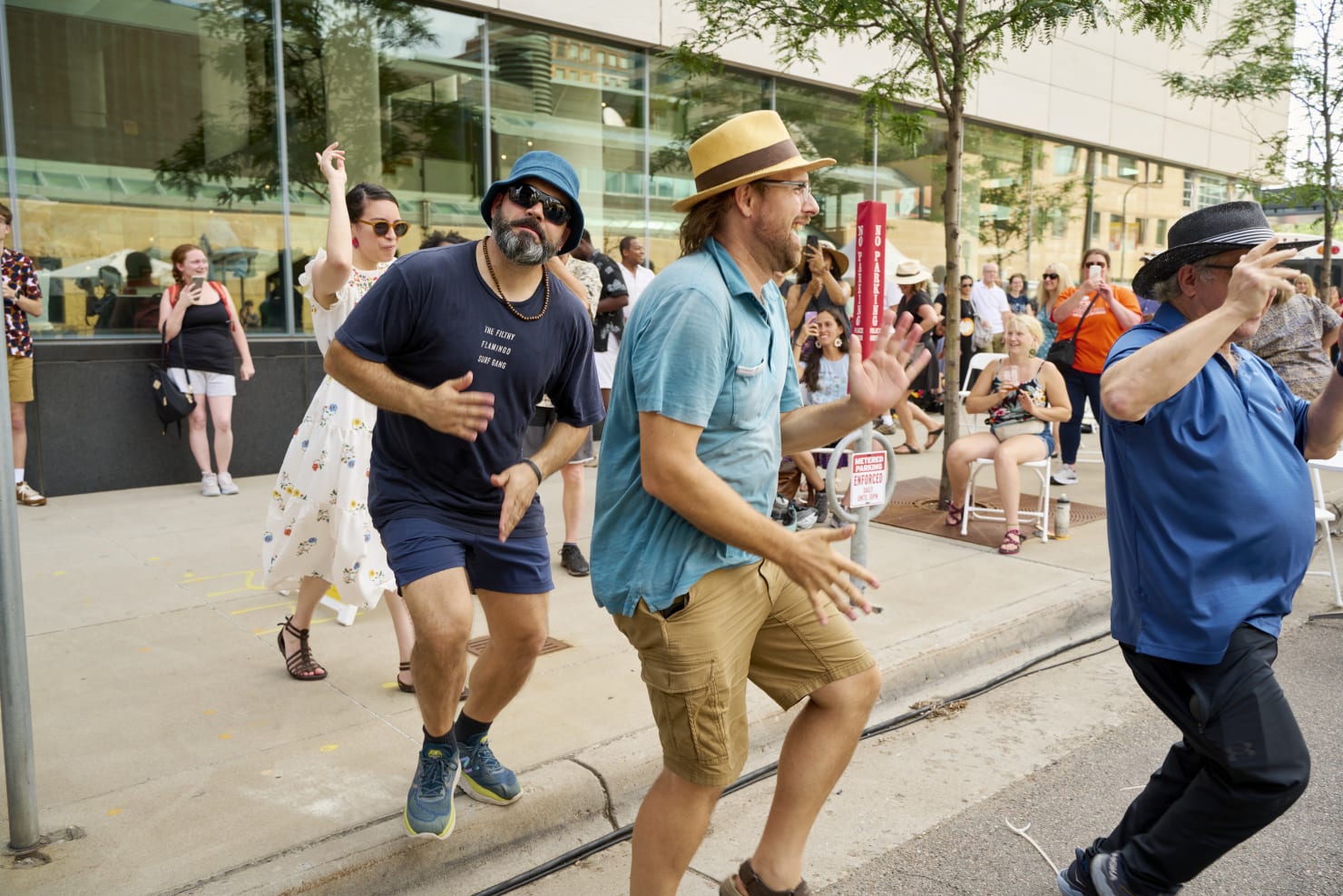 A line of people dancing outdoors.