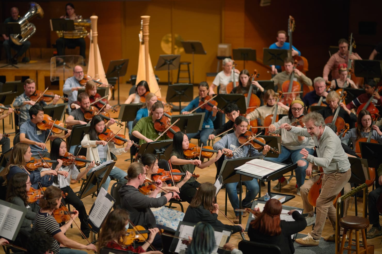 A wide-angled shot of Søndergård conducting an Orchestra mixed with students and professional musicians.