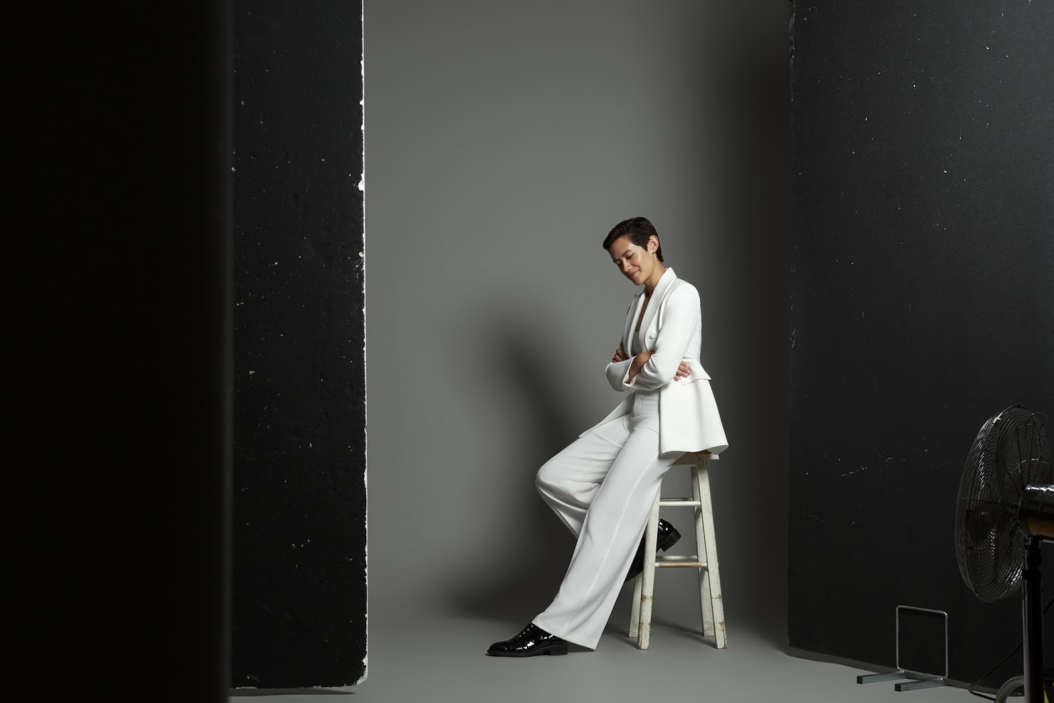 Stephanie Childress posing on a stool in a photo studio.