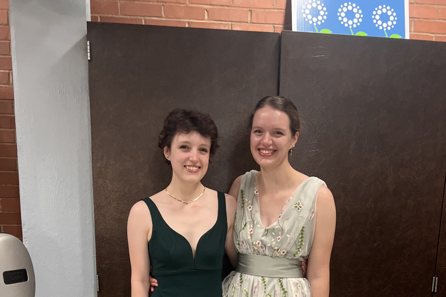 Two women--Emily and Sarah--posing next to one another in long dresses.