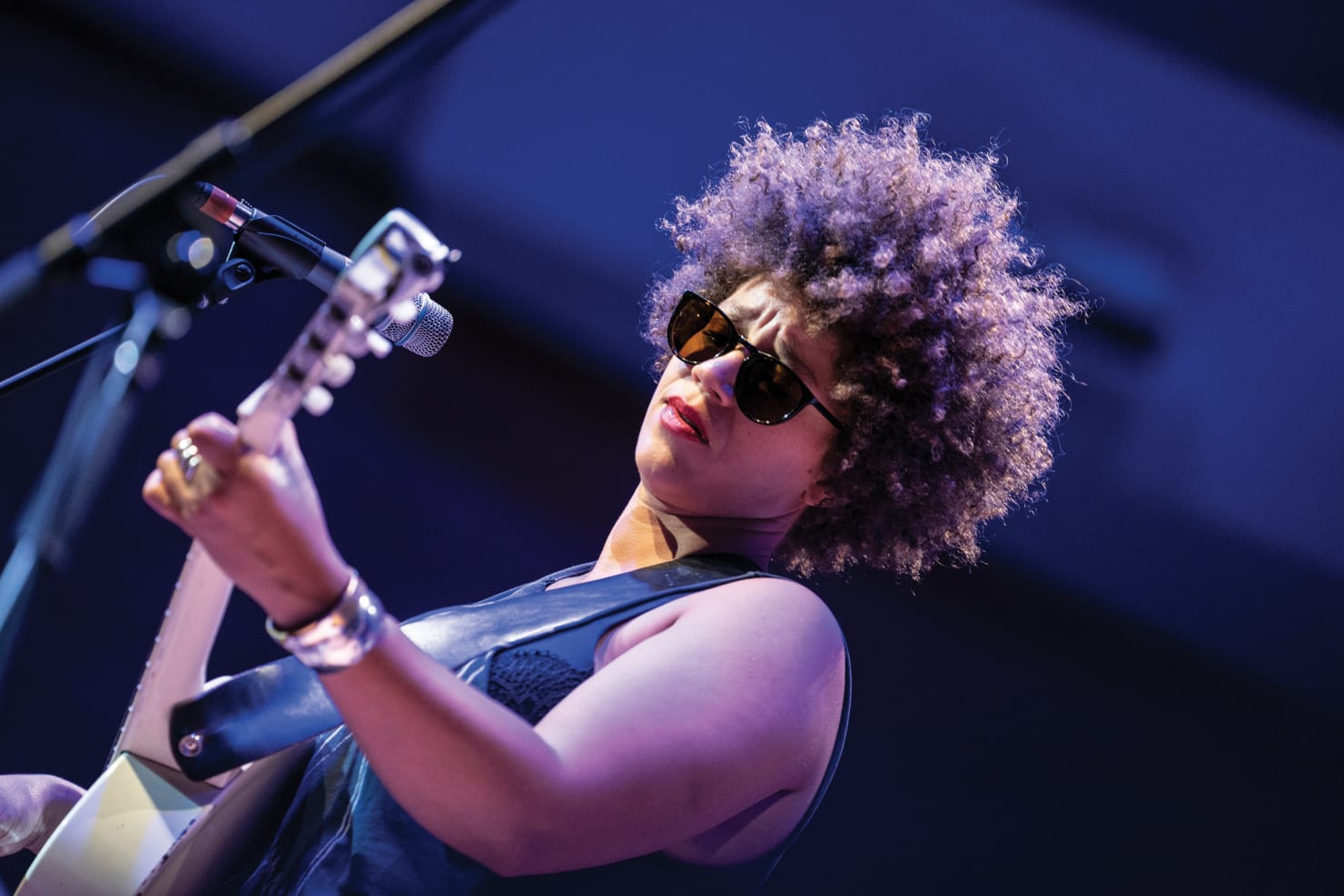 An image of Chastity Brown, onstage, playing the guitar.