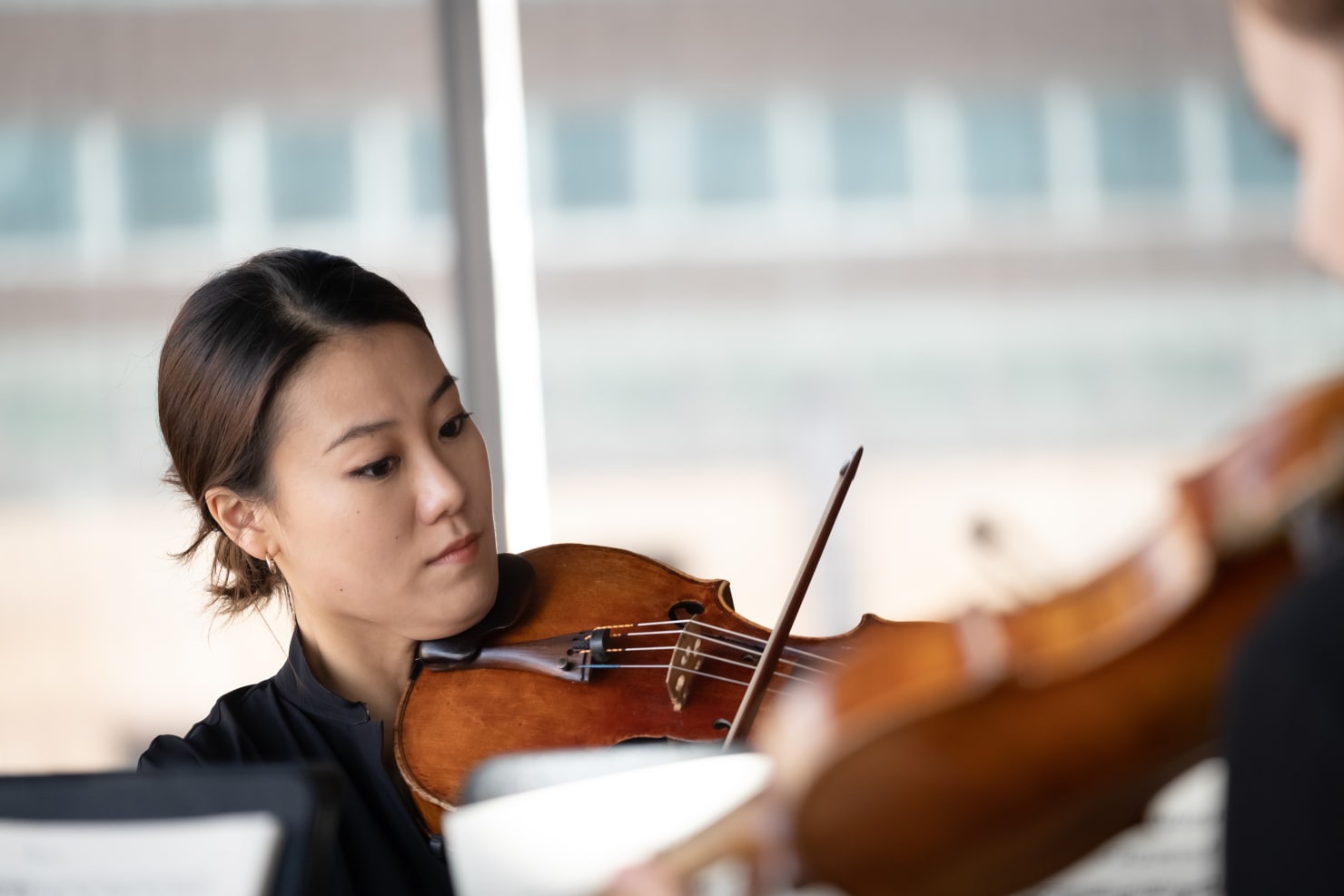 A close-up of violist Jenni seo playing her instrument