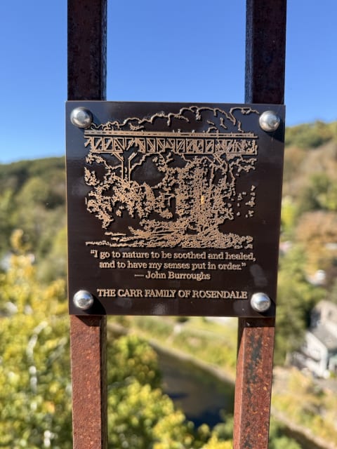 A plaque on the Rosendale Trestle bridge with the quote 'I go to nature to be soothed and healed, and to have my senses put in order'