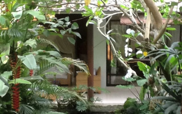 Das Paradies: Gartenhaus in einem üppigen tropischen ummauerten Garten 