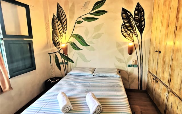 Zweibettzimmer mit Deckenventilator und Seitenfenster.
