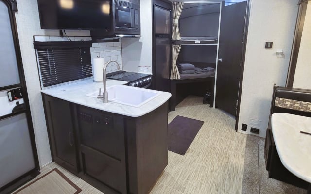 Kevins Inserat auf misterb&b - The kitchen island makes this RV feel almost like a real house.  The television above the island is on a swing arm so it can be watched easily throughout the cabin.