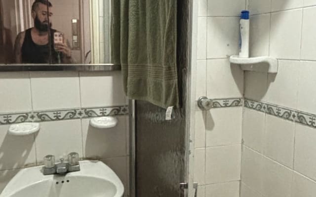 Una habitación amplia, con espacios compartidos como baño y ducha.