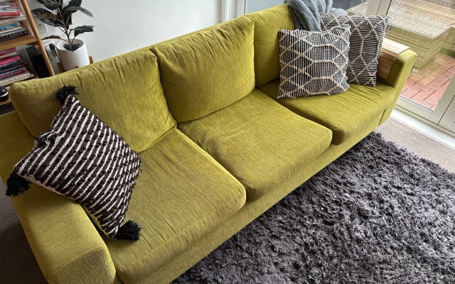 A townhouse with a couch located near the airport and the city.