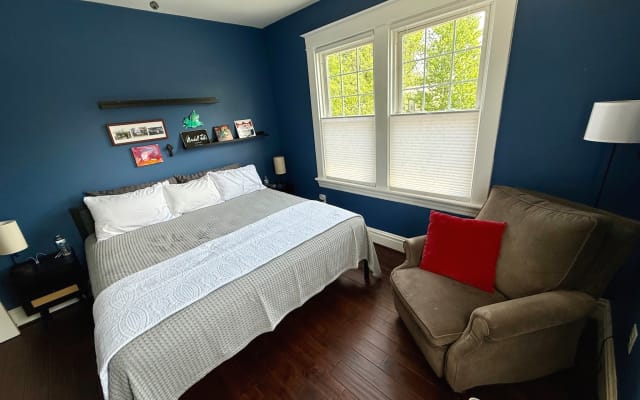 Annonce de Kevin sur misterb&b - This Boston Terrier bedroom features a king size bed, desk, sitting chair, storage ottoman, generous closet space and an Alexa enabled speaker. USB charging throughout. 