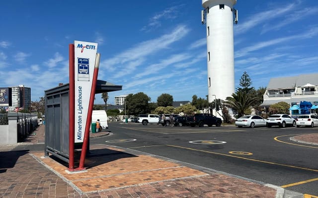 Anúncio de Freddie em misterb&b - Uma das principais caraterísticas da ilha de Woodbridge é o icónico farol em funcionamento. À direita está o centro de restaurantes/bares desportivos da ilha. Claramente visível é o terminal do serviço de autocarros MyCity, que fornece serviço de autocarros para a cidade de Century e para mais longe