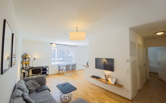 Lisas Inserat auf misterb&b - Dieses helle und einladende Wohnzimmer strahlt Gemütlichkeit aus. Ein bequemes Sofa lädt zum Entspannen ein, während der Esstisch am Fenster für gesellige Stunden bereitsteht. 