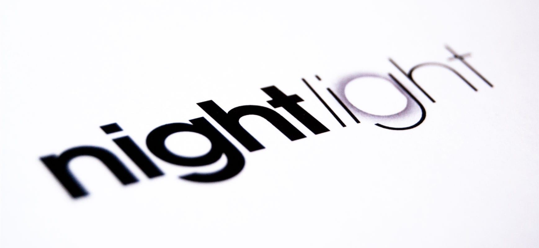 close up shot of black night light logo printed on white paper