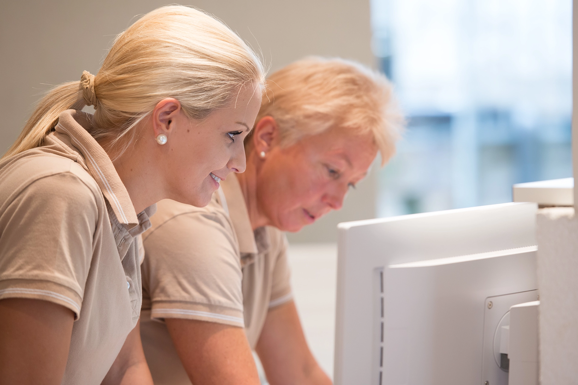 two woman looking at a monitor screen