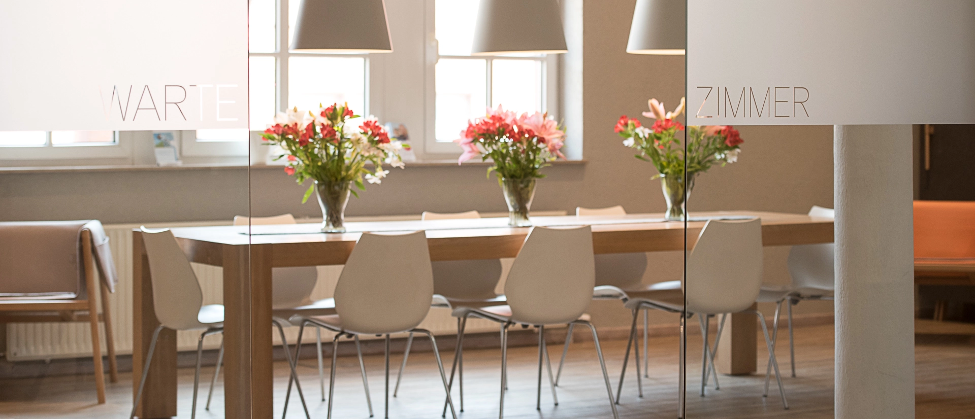 Praxis inside with a desk and flowers on top