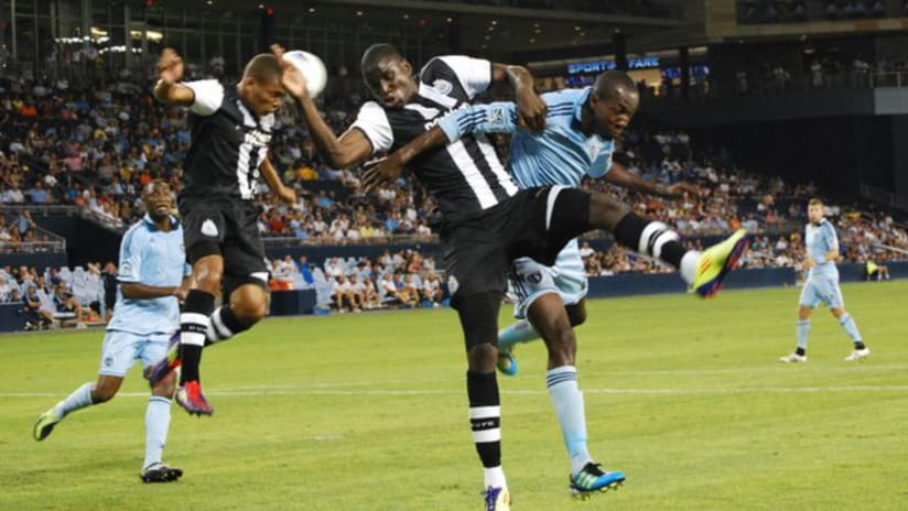 Daneil Cyrus tangles with a Newcastle United attacker