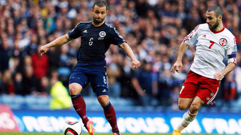 Shaun Maloney, Scotland, holds off Georgia's Jaba Kankava.