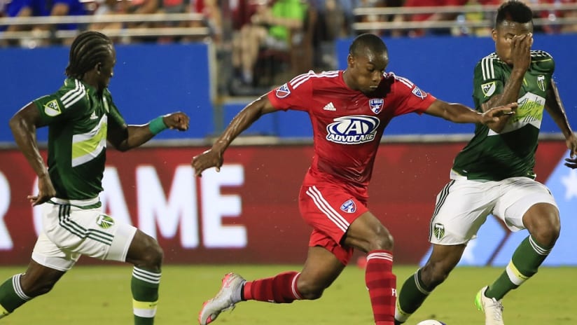 Fabian Castillo (FC Dallas) dribbles against Diego Chara and Alvas Powell (Portland Timbers)