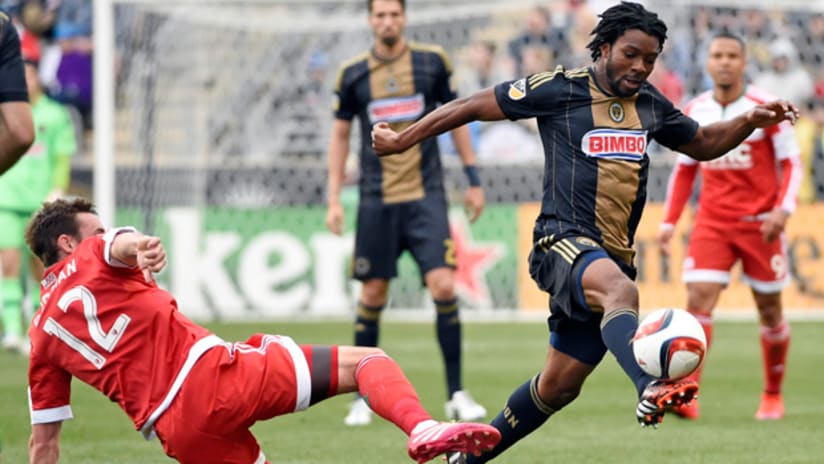 Michael Lahoud (Philadelphia Union) takes the ball past Andy Dorman (New England Revolution)