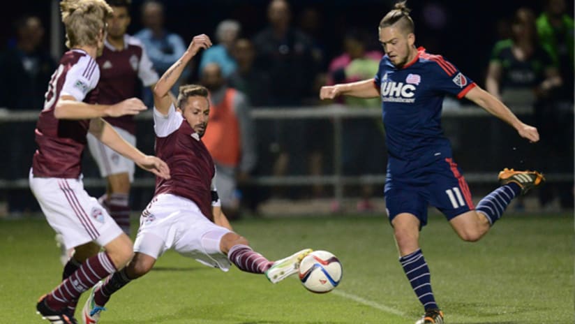 Kelyn Rowe (New England Revolution) takes a shot as Marcelo Sarvas (Colorado Rapids) attempts a block in preseason