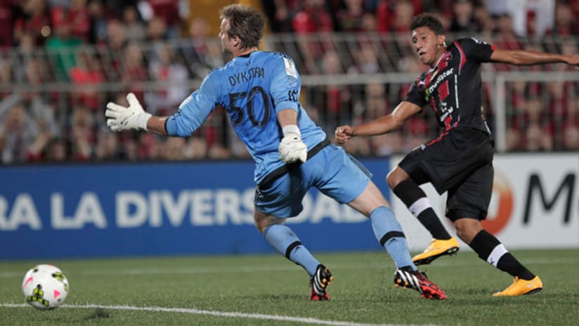 Alajuelense's Jose Ortiz scores past D.C. United's Andrew Dykstra in CCL play