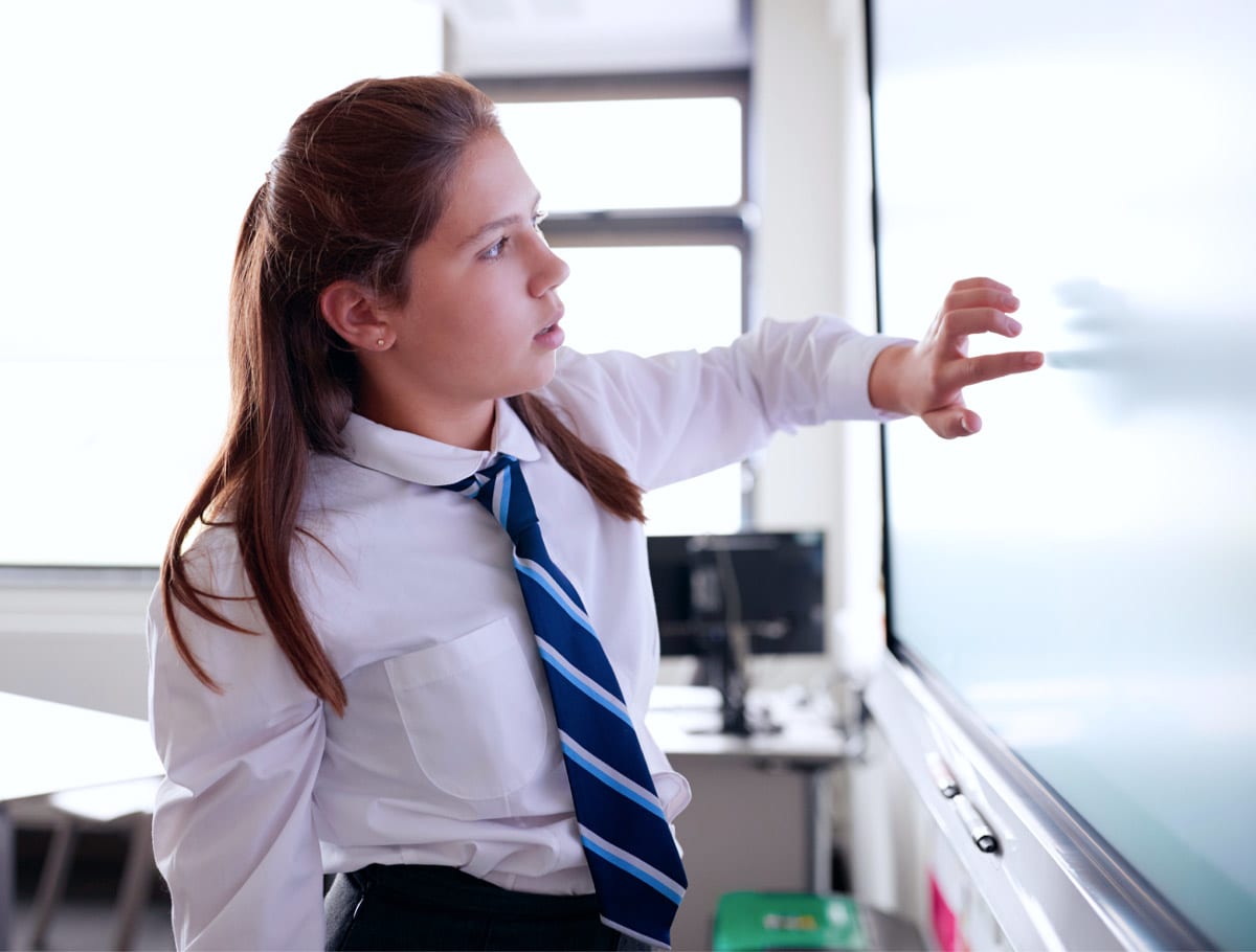 High school student working on an interactive whiteboard