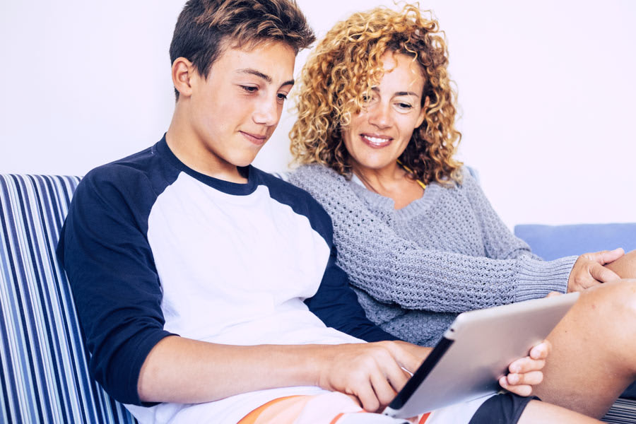 confident student learning maths at home with his mother