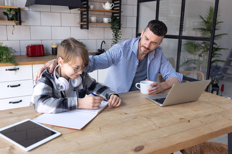 father helping son address his maths homework