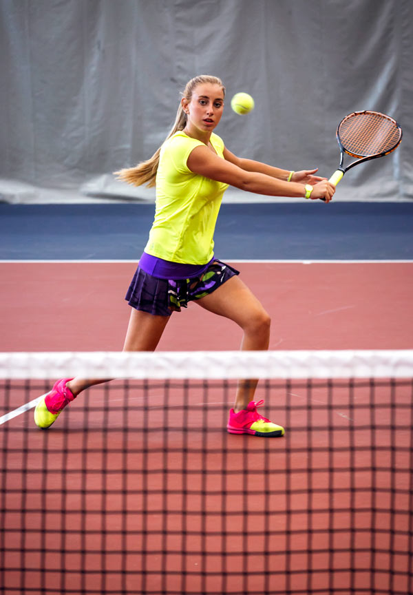 student playing tennis at school