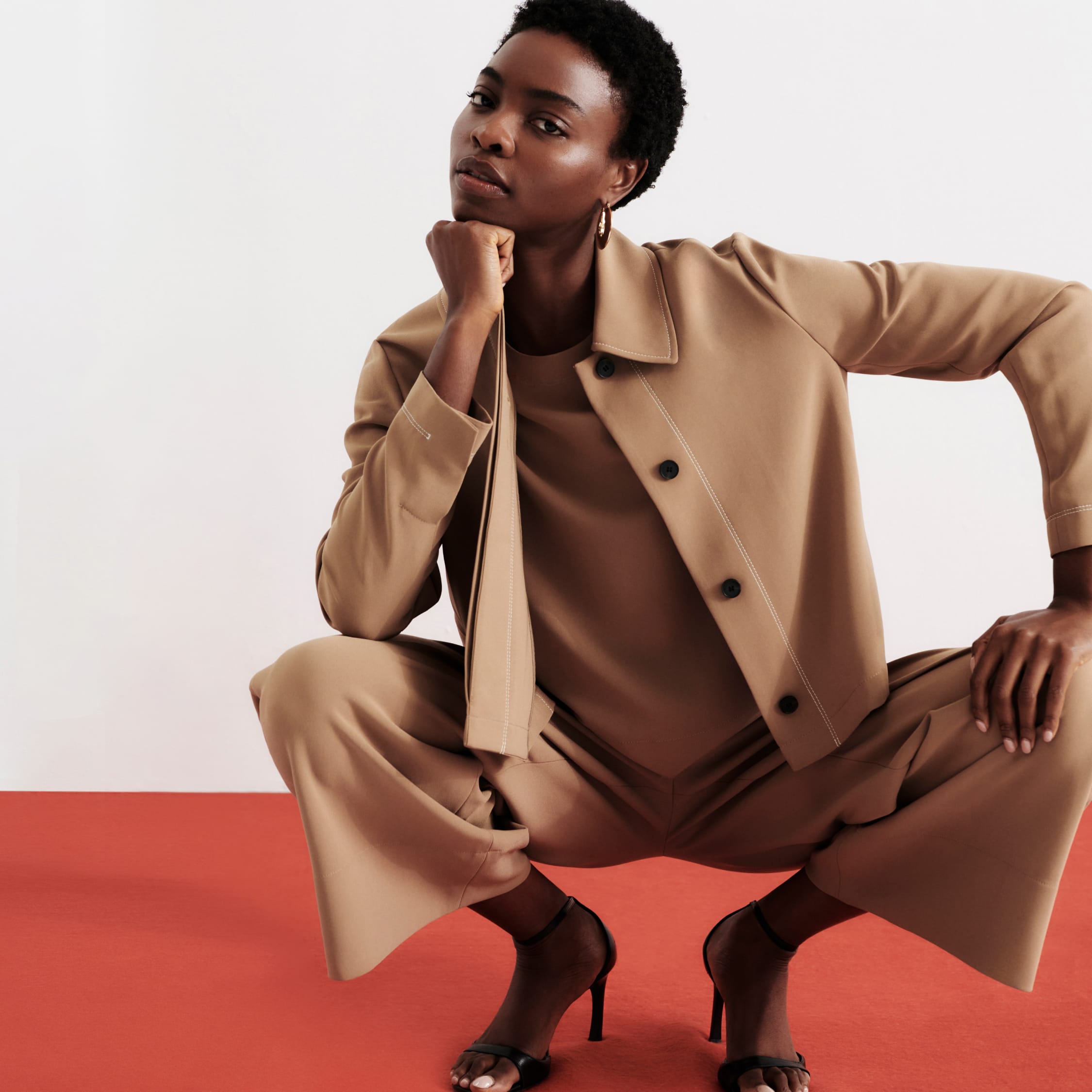 woman crouching wearing light saddle Nicky jacket, short-sleeve Annika top, and wide-leg Elena culotte