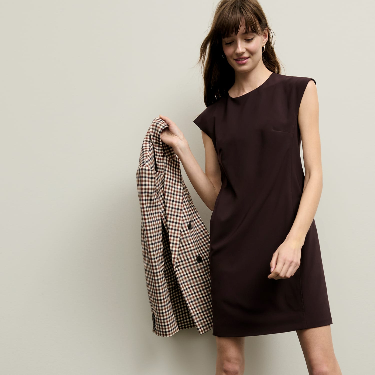 woman standing wearing the maaza dress in wine and the o'hara blazer in wondowpane