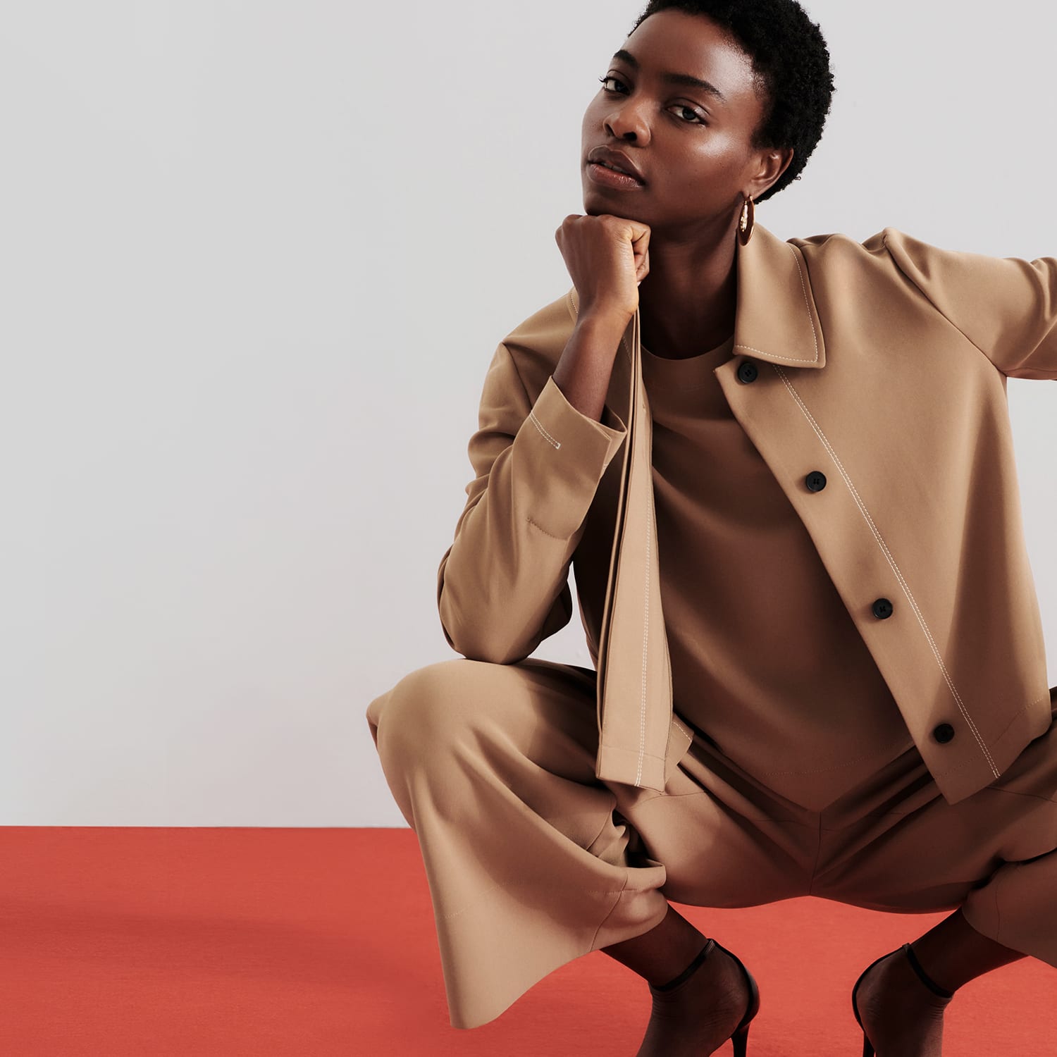 image of a woman sitting wearing the nicky jacket, annika top, and elena pant in light saddle