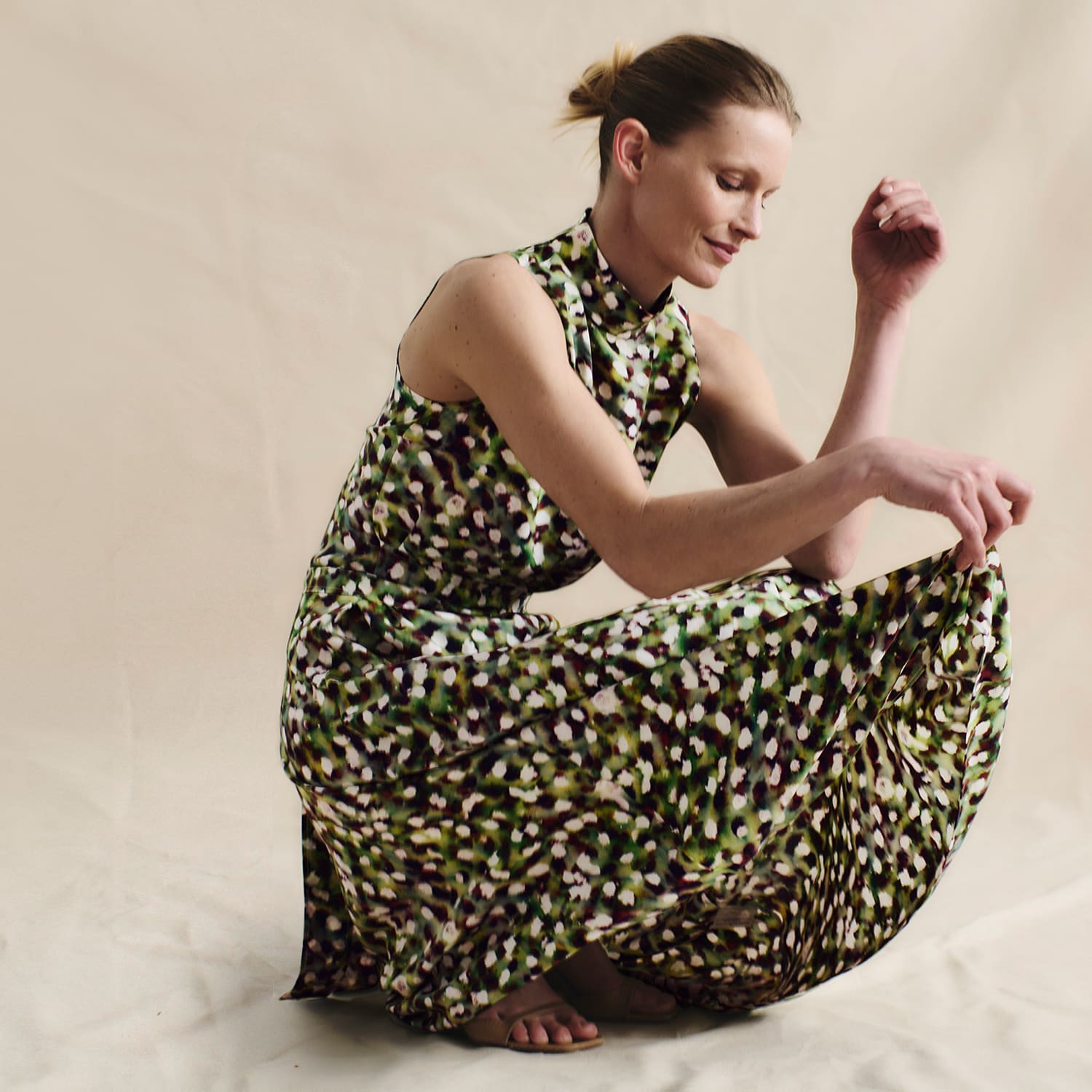 image of a woman kneeling while wearing the martina dress in spotlight print