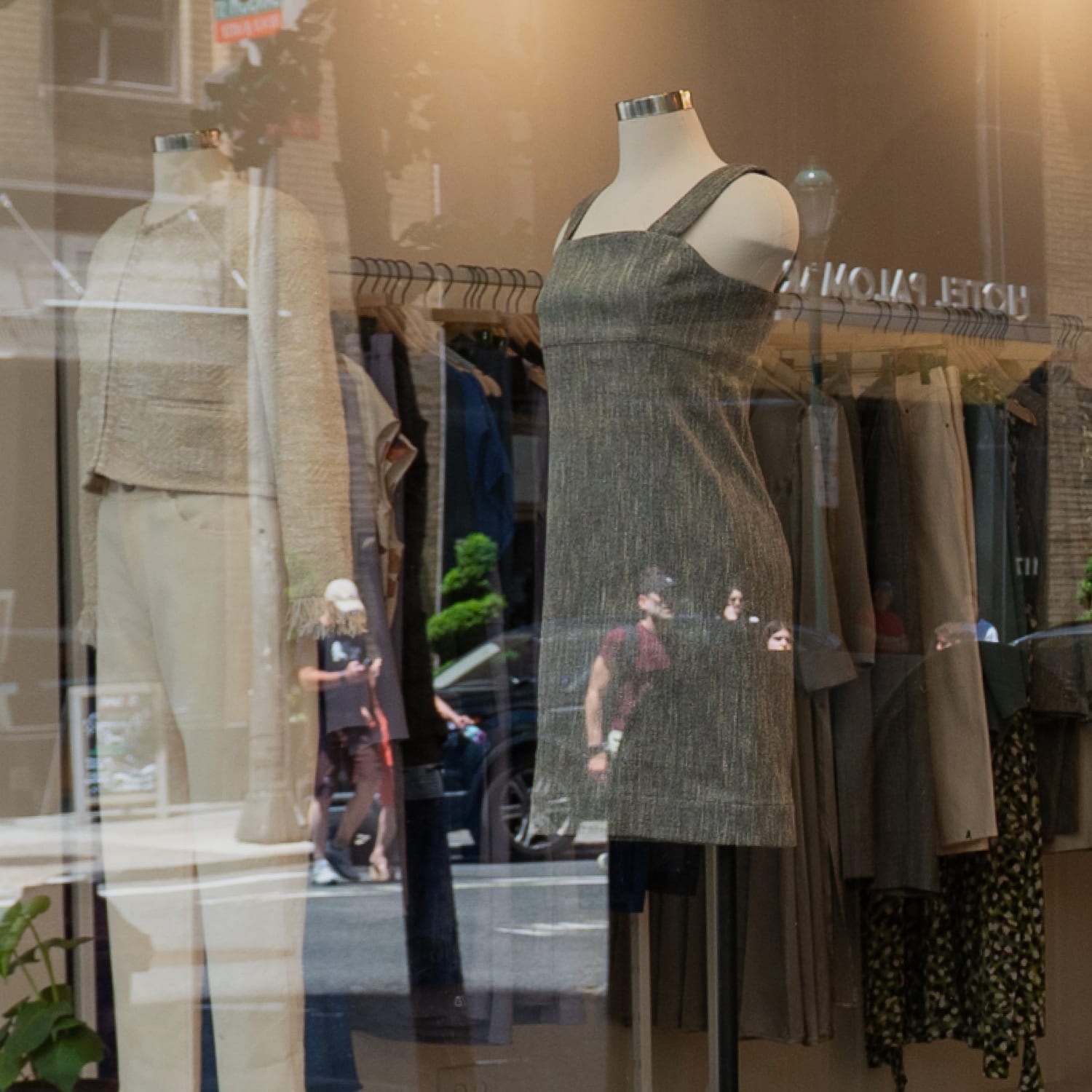 Exterior of M.M.LaFleur Philadelphia store: mannequins in a window dressed in a green sleeveless dress, gray dress, and white cardigan with white jeans