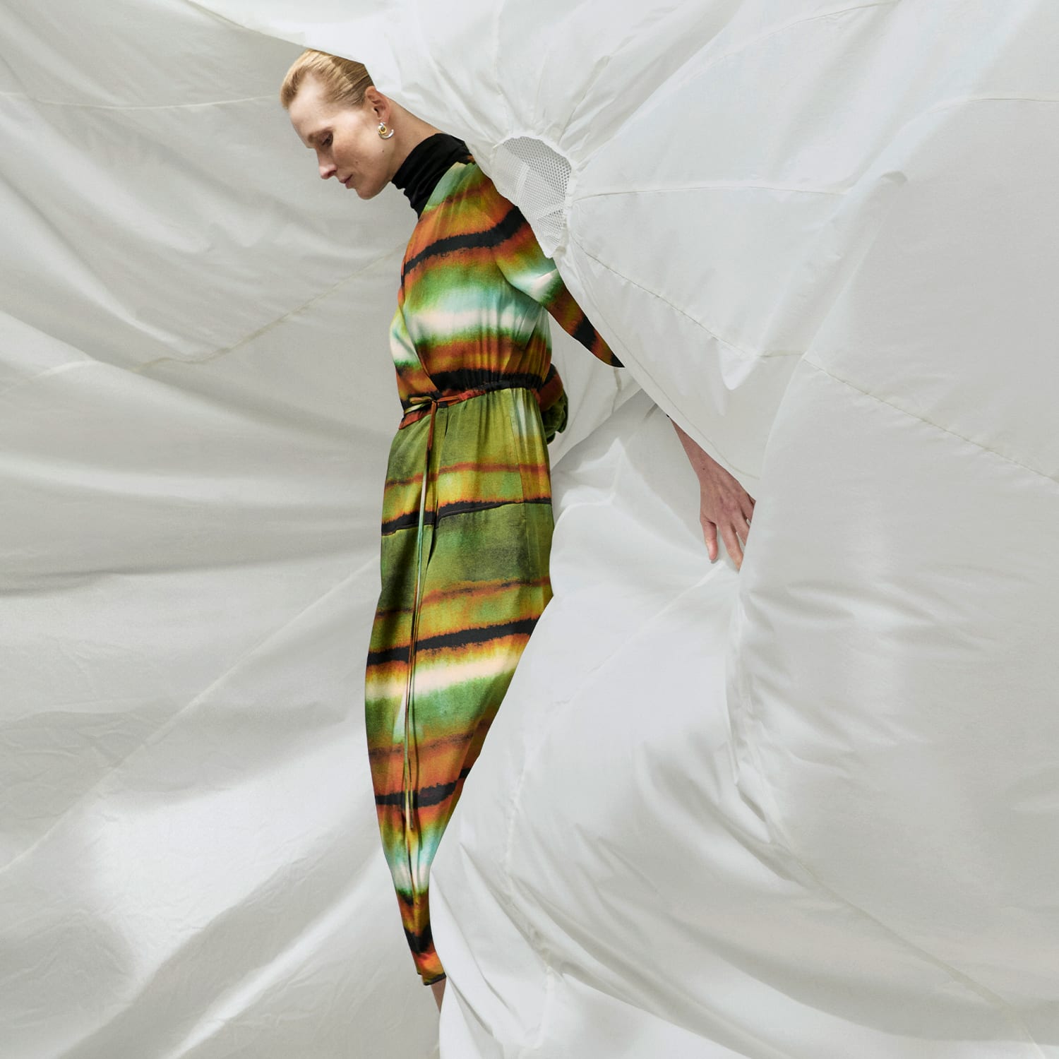 image of a woman wearing the Deana dress in faded print in front of a white parachute