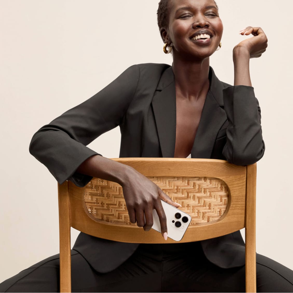 image of a woman sitting in a chair with an olive colored suit on