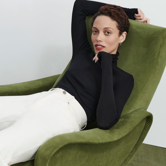 woman sitting wearing the elizabeth top in black and the milo jean in tusk