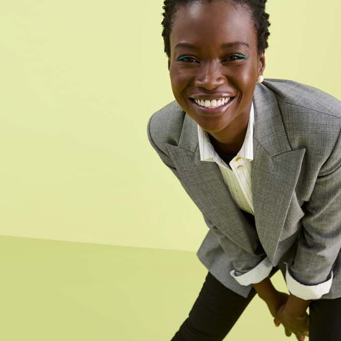 2 women standing on a yellow backdrop