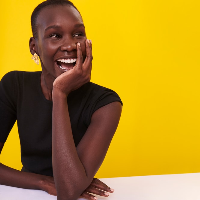 woman sitting at a table wearing a black shirt