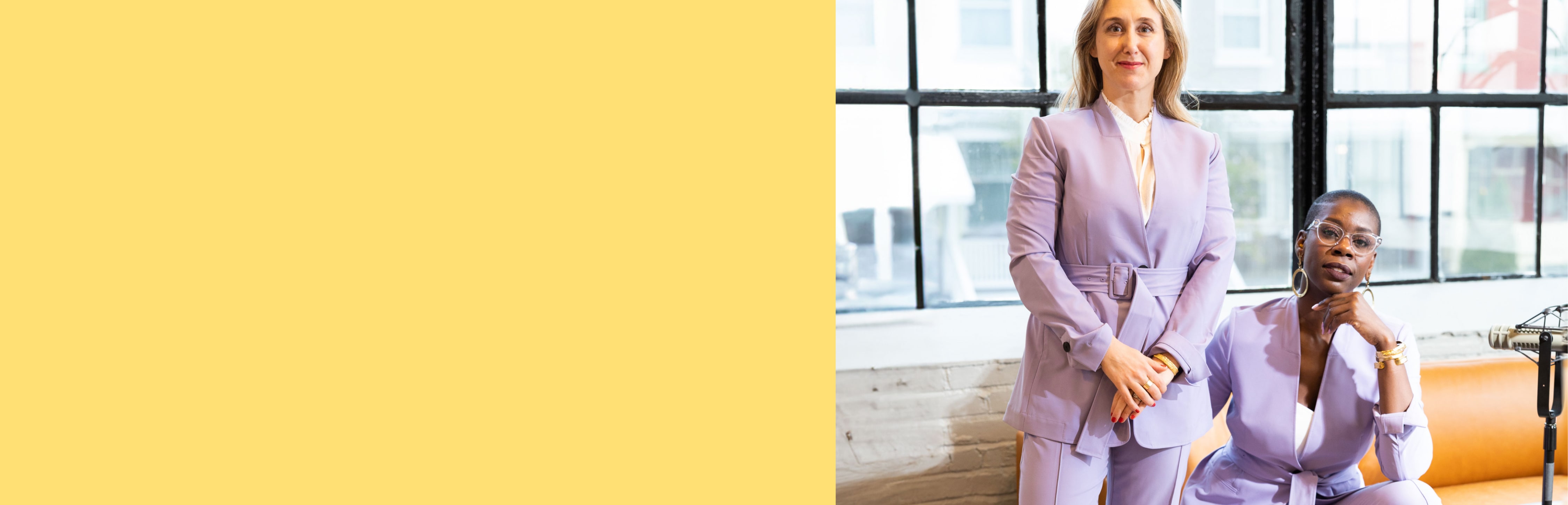 image of justUS podcast co-hosts Margo Lindauer, standing, and Tashira Halyard, seated, wearing light orchid suits