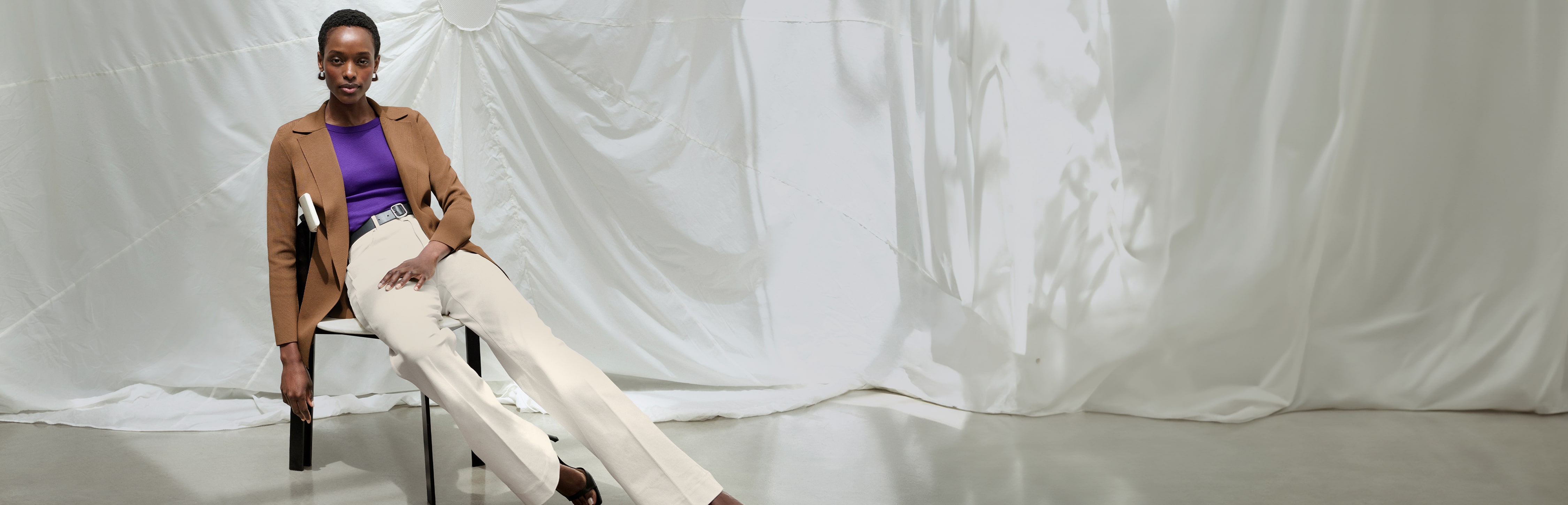 image of a woman standing in a red shirt and white jeans