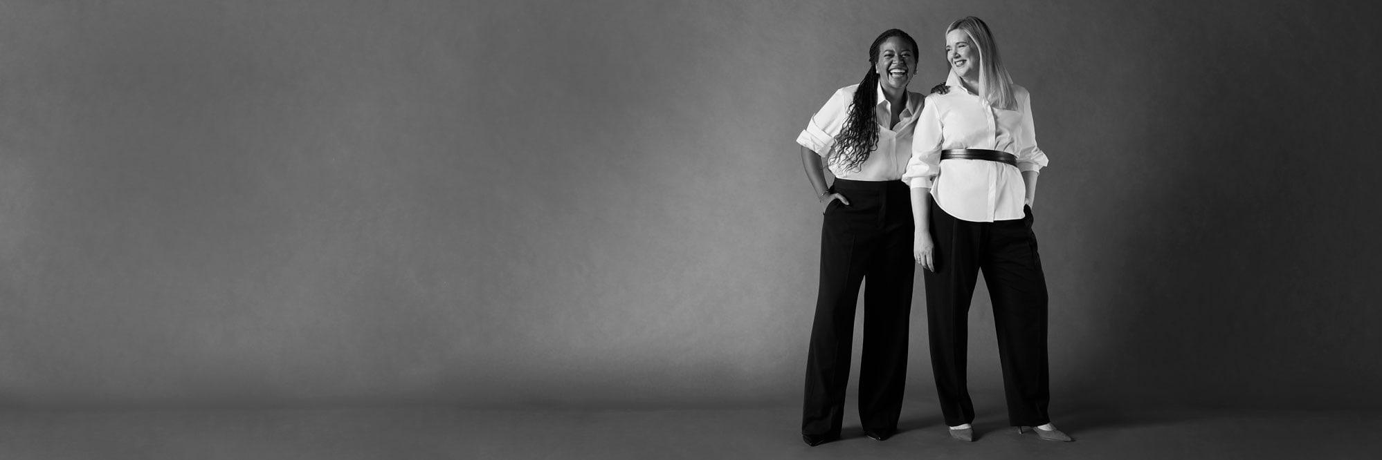 Two women wearing white shirts and black pants