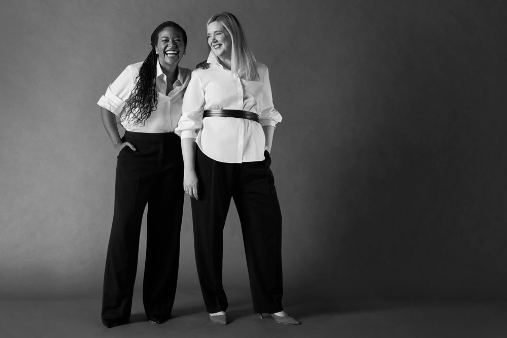 Two women wearing white shirts and black pants