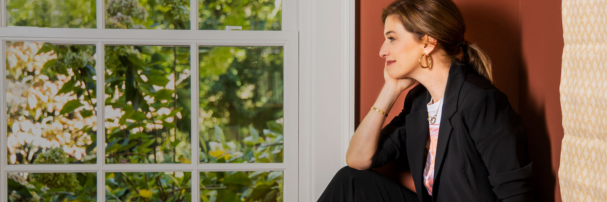 pati jinich lying down on couch in tatum hunter and black pants