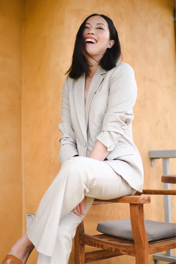 woman sitting wearing a natural melange colored wool suit