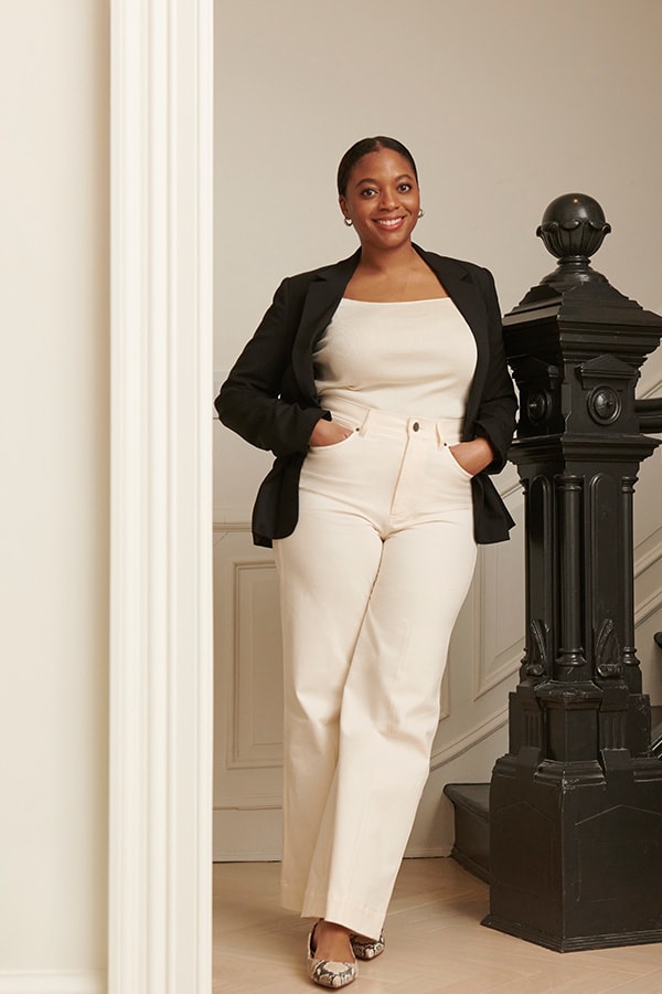 image of a woman wearing an ivory top and pants with a black blazer and snakeskin shoes